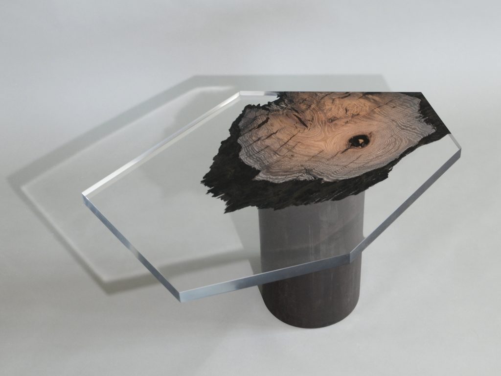 side table made of a brown wooden log and thick transparent glass top in the shape of a hexagon