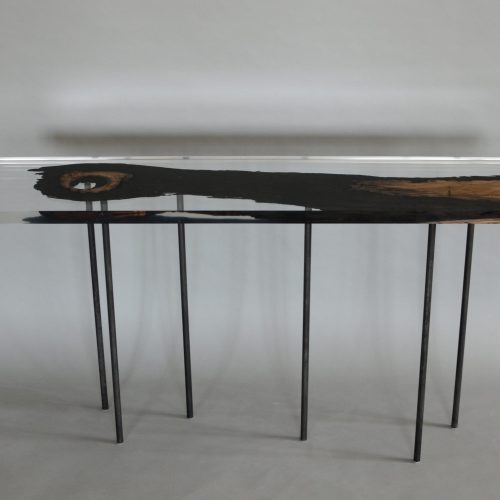 table made with a base of steel legs and a wooden top covered in resin in a brown and transparent tone