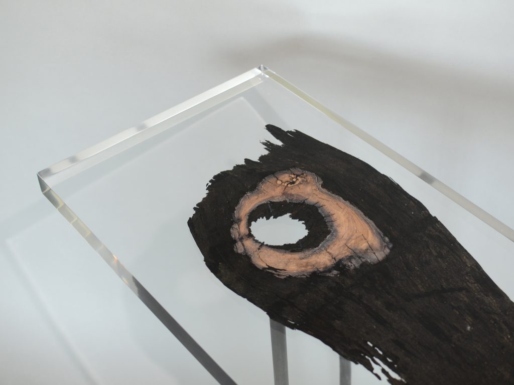bar table made of resin and natural wood in a brown and transparent tone on a gray background