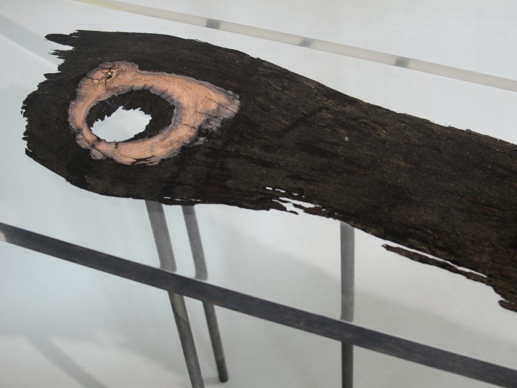 bar table made of resin and natural wood in a brown and transparent tone on a gray background