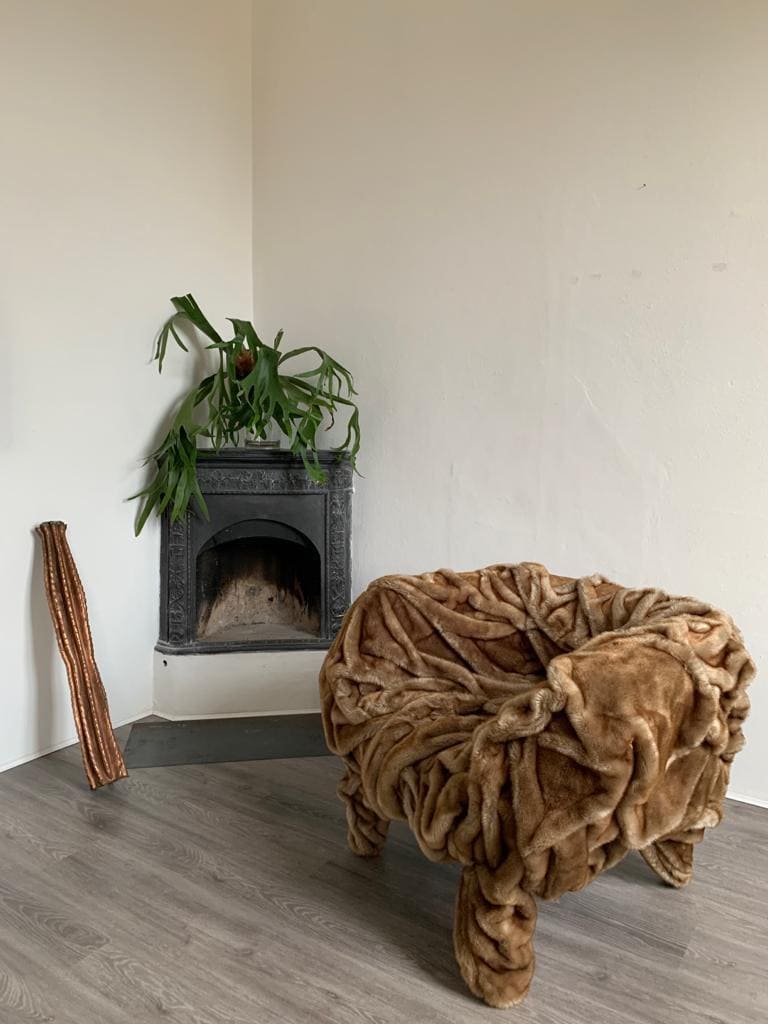 Grinza Chair featuring a unique wrinkled leather design in a minimalist interior setting