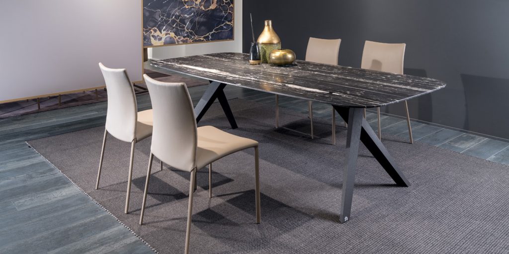 table made of wooden legs, top made of gray wood and top made of black marble with some chairs around it
