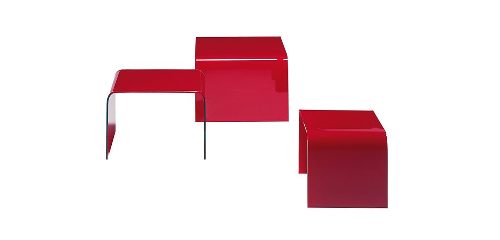 three side tables made of glass in a red tone on a white background