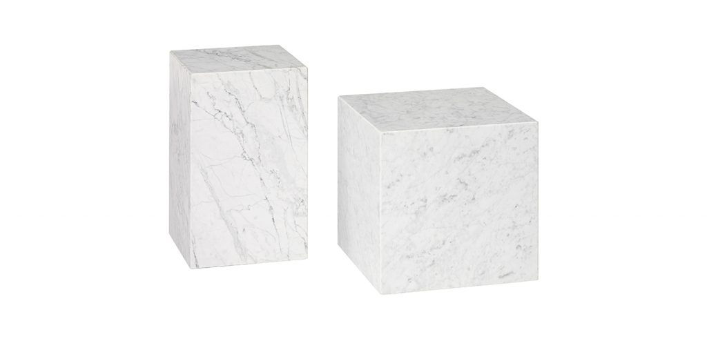 two small sculptures made on a natural stone base in the shape of a cube in shades of white on a white background