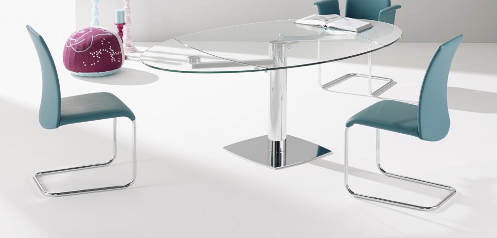 extendable dining table made of black glass with two leaves on a transparent steel base in a living room