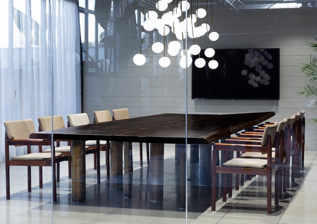 Rectangle 10th Joint Dining Table in brown wood and materic slabs connected by burnished brass joint in a dining room.