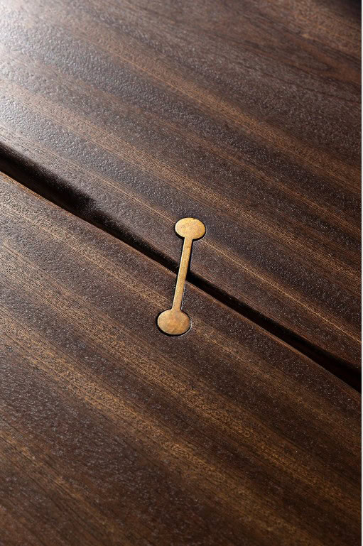 Closeup of Rectangle 10th Joint Dining Table in brown wood and materic slabs connected by burnished brass joint.