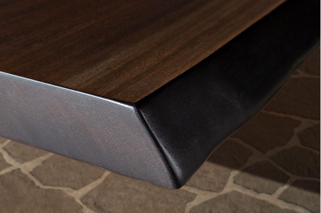 Closeup of Rectangle 10th Joint Dining Table in brown wood and materic slabs connected by burnished brass joint.