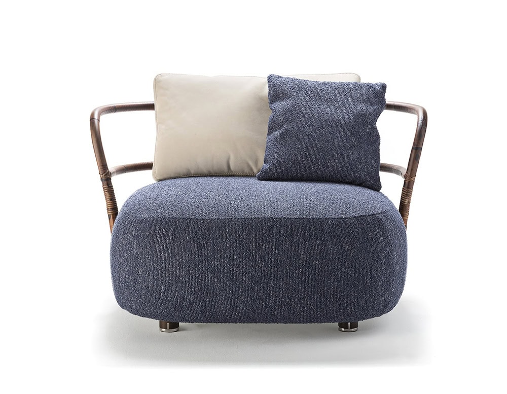 A front view of the Jungle Armchair featuring a curved wooden frame plush blue cushion and dual-tone backrest pillows for a stylish modern look