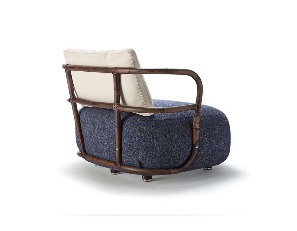 A rear view of the Jungle Armchair showcasing its elegantly curved wooden frame woven backrest and plush blue cushion for a sophisticated look