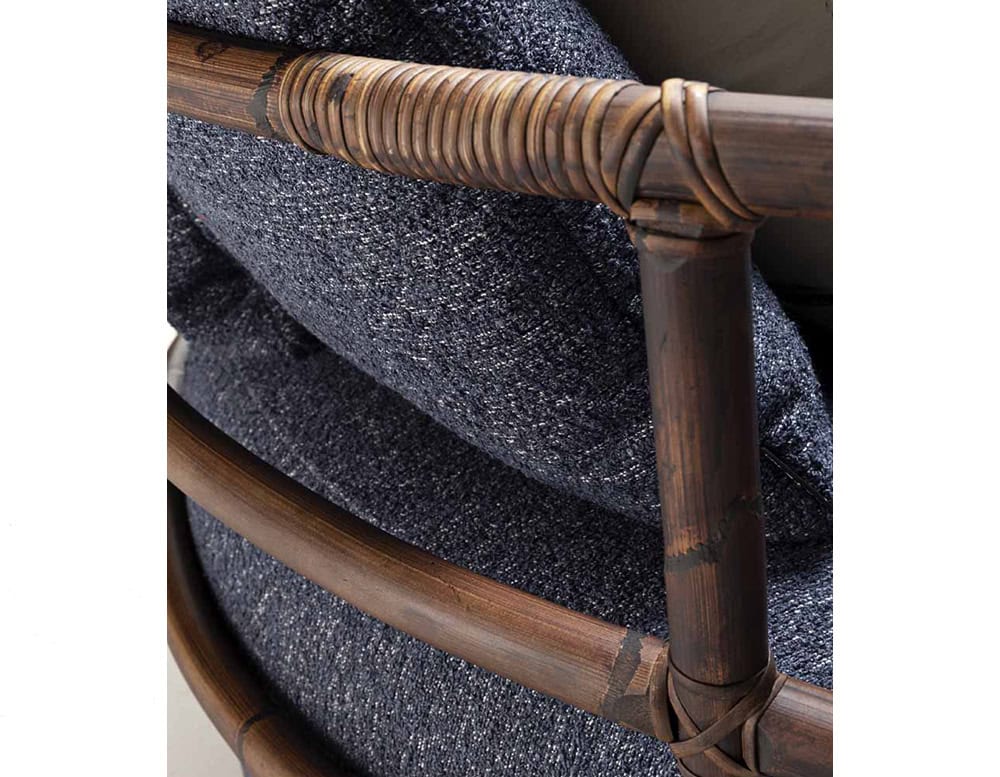 A detailed close-up of the Jungle Armchair showcasing its intricately wrapped wooden frame and plush textured blue cushion