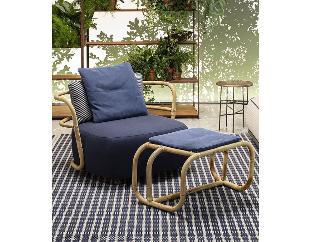 Jungle Armchair Slim upholstered in blue fabric and brown wooden structure in a living room.