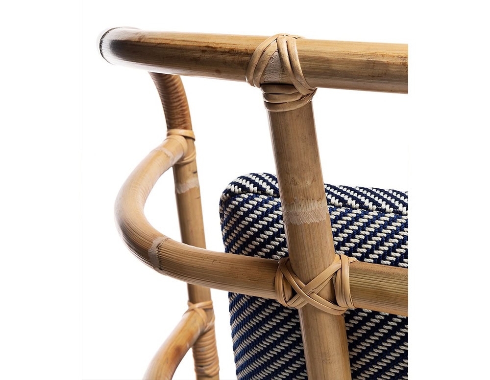 Closeup of Jungle Armchair Slim upholstered in gray fabric and brown wooden structure on a white background.