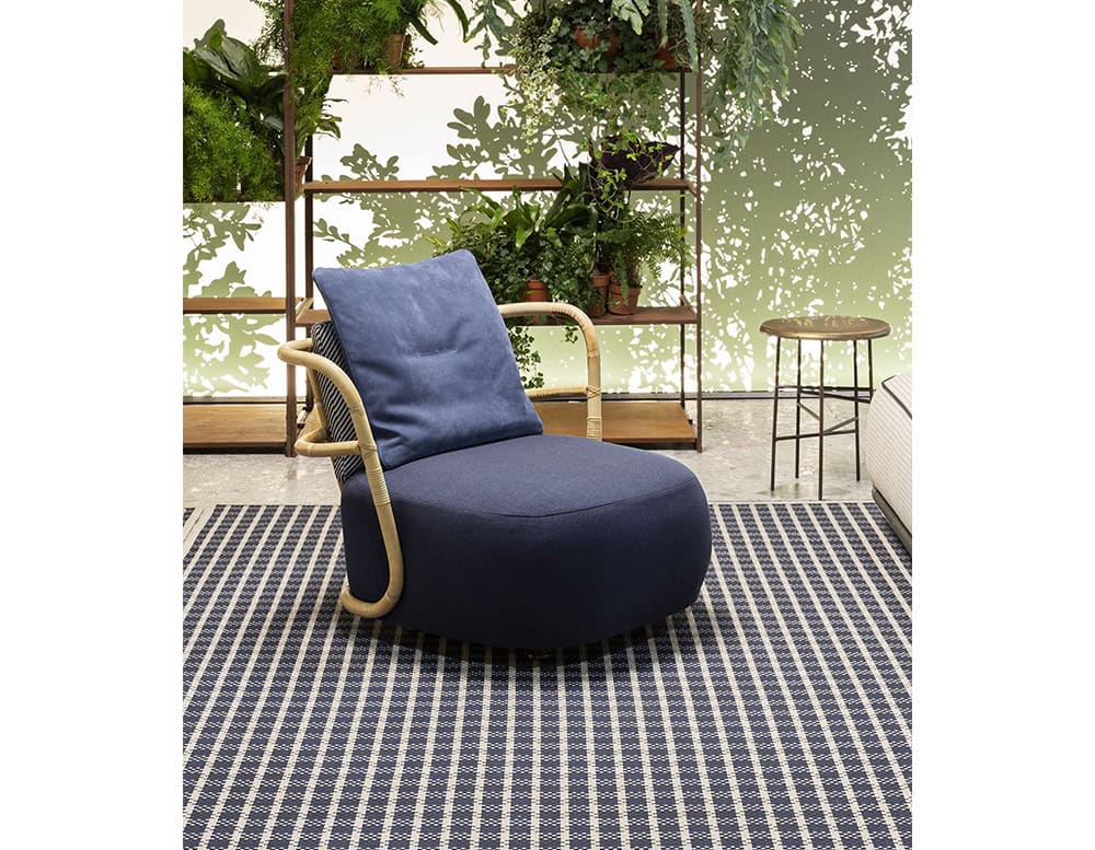 Jungle Armchair Slim upholstered in gray fabric and brown wooden structure in a living room.