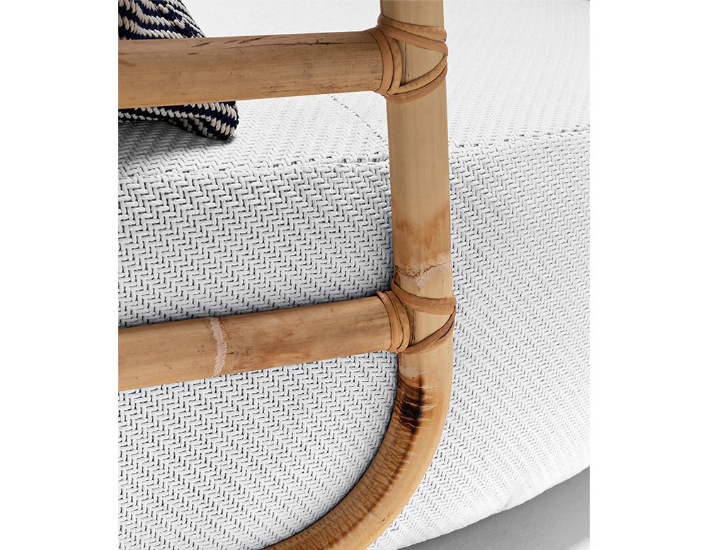 Closeup of Jungle Daybed upholstered in gray fabric and brown wooden structure on a white background.