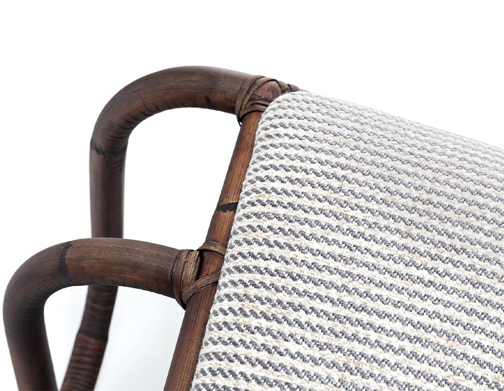 Closeup of : Jungle Pouf upholstered in gray fabric and brown wooden structure on a white background.