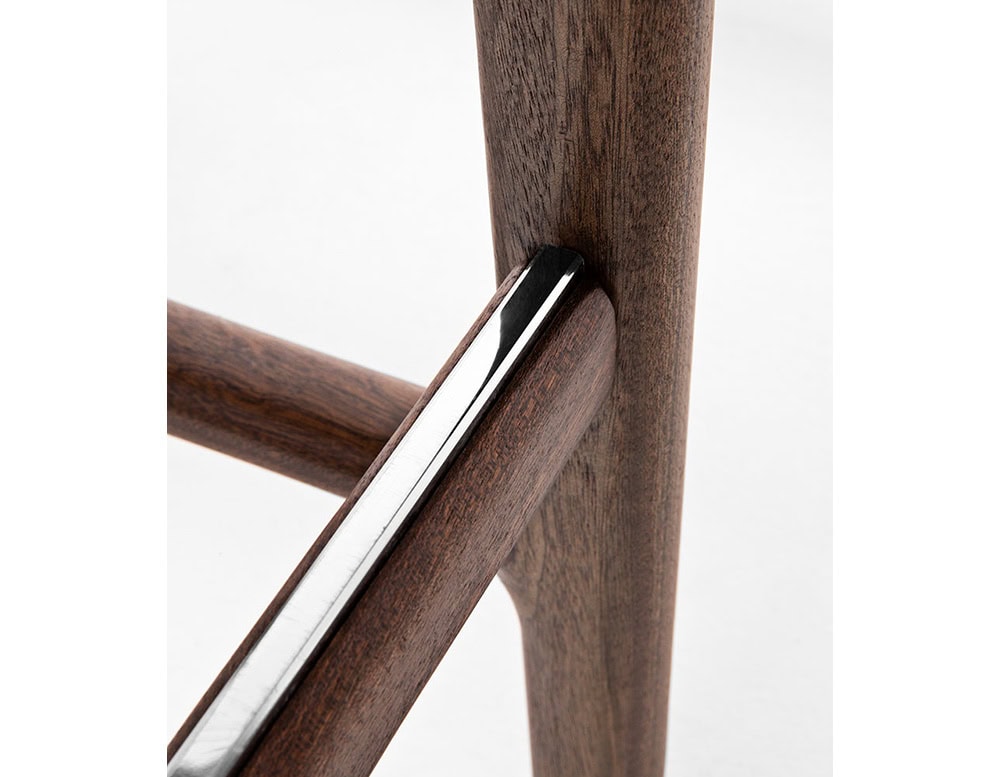 Closeup of Levante Stool. Structure in brown wood on a white background.