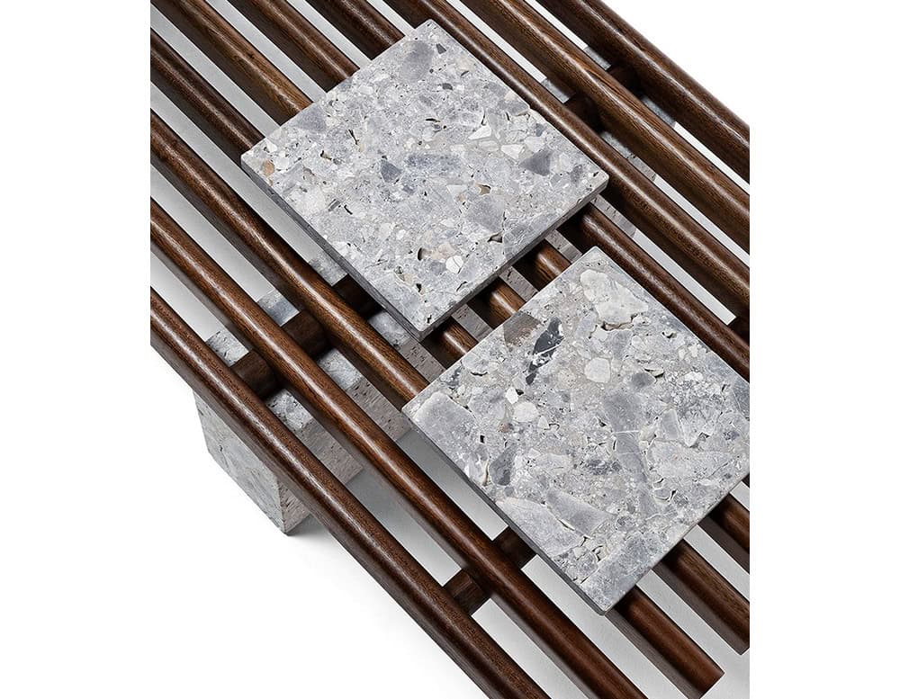 Closeup of Panarea Coffee Table. Upper part made of brown wooden sticks and lower part is a block of yellow stone on a white background.