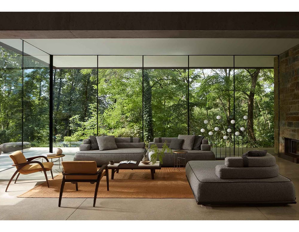 : Two Panarea Sofas in gray fabric with backrest and cushions in a living room.