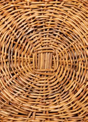 Cube-shaped pouf made of various hand-woven wooden fabrics in a brown tone