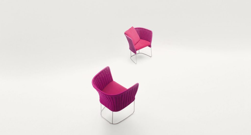 Ami Outdoor Chair: Two pink woven chairs with a curved backrest on a white background.