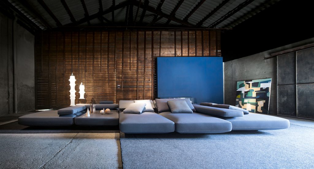 Agio Modular sofa composed of large platforms, backrest can be adjusted, all upholstered in blue fabric in a living room.