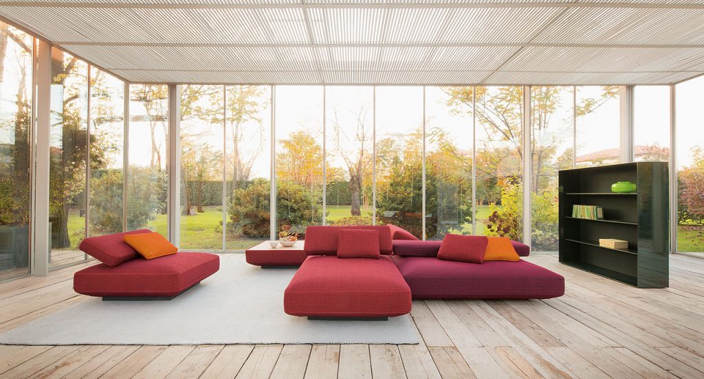 Agio Modular sofa composed of large platforms, backrest can be adjusted, all upholstered in red fabric in a living room.
