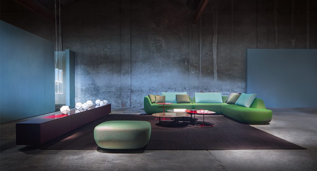 Four red side tables, base in steel, top in fibreboard in a living room.