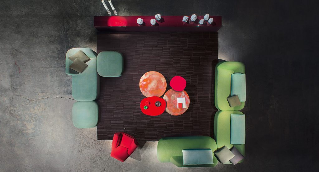 Two red Ivy side tables, base in steel, top in fibreboard in a living room.