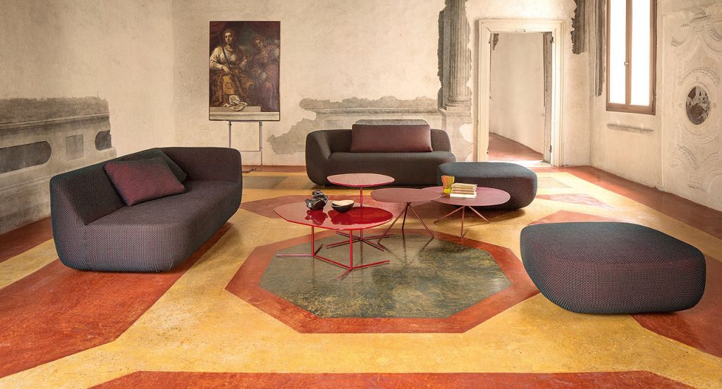 Two red Ivy side tables, base in steel, top in fibreboard in a living room.