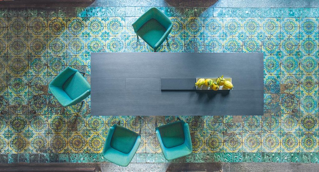 Black Kanji Dining Table, top in fibreboard and two legs in wood, one black cutting board and one white metal tray in a living room.