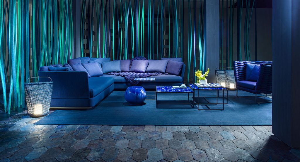 Blue Calatini side table with abstract shape, blue falling paint pattern in a living room.