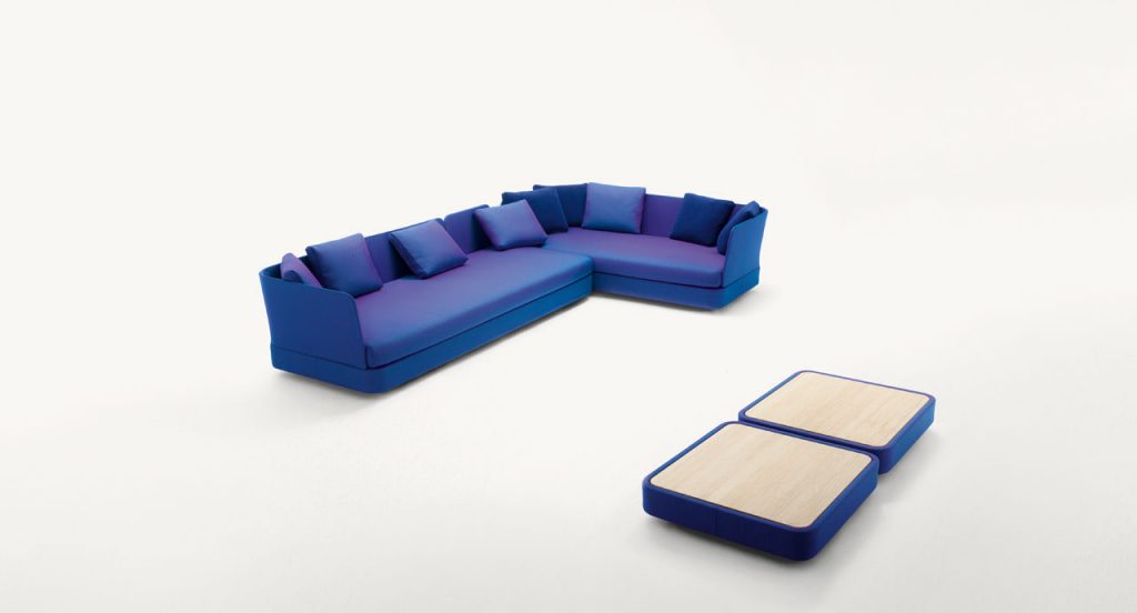 Two Cove Sectionals, upholstered in blue purple fabrics on a white background.