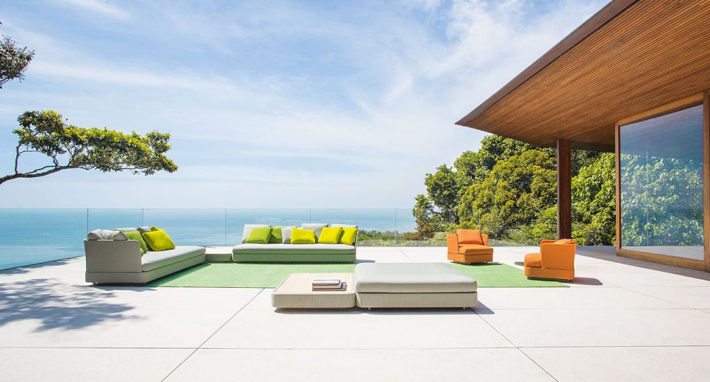 Two Cove Sectionals, upholstered in grey fabrics, cushion in white fabrics in a terrace.