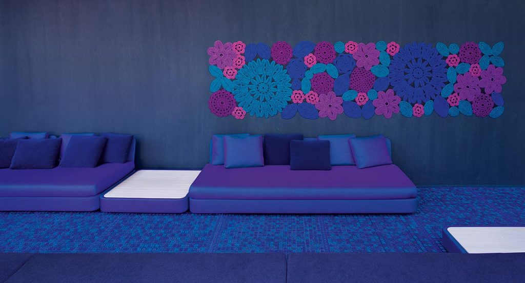 Two Cove Sectionals, upholstered in blue purple fabrics in a living room.