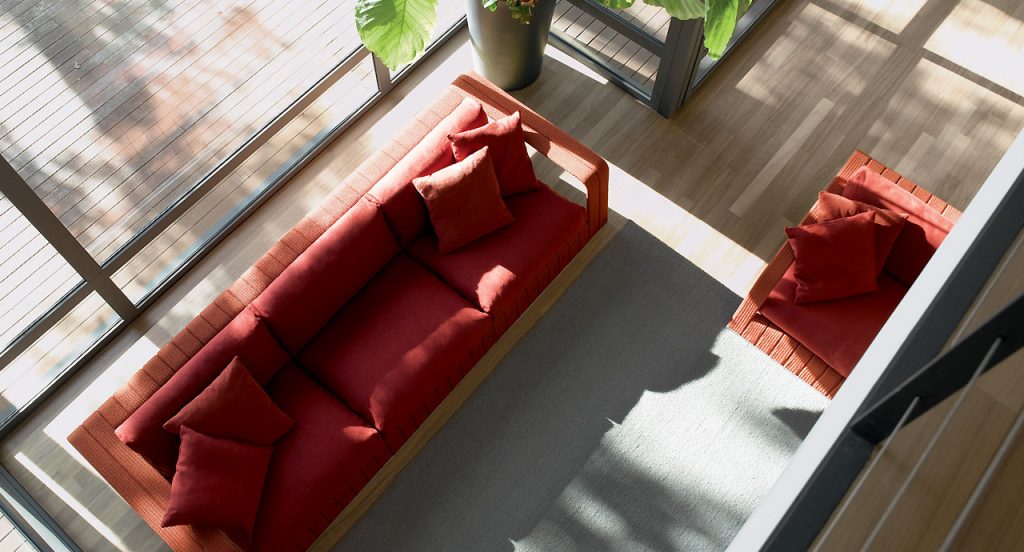 Red Frame Sectional sofa, upholstery in rope braids with four cushions in a living room.