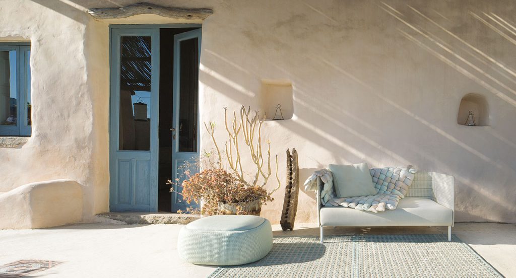 Frame on sofa, legs in steel, upholstery in white rope braids, white seat cushion in a living room.