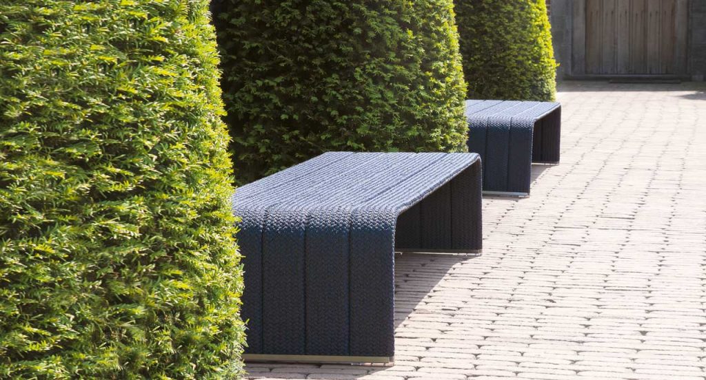 Two square Frame Coffee Table, upholstery in blue rope braids in a garden.