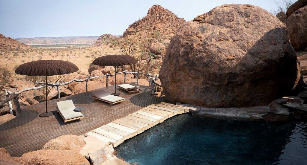 Two Mogambo parasols, structure in black aluminium and steel, top of brown rope yarn in a terrace.