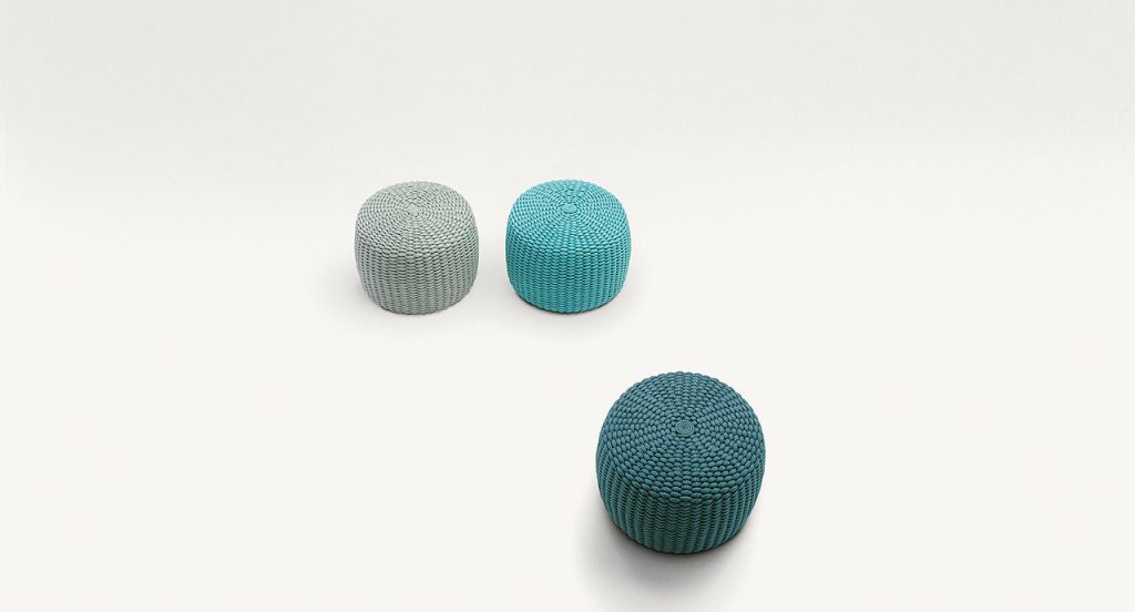 Three Nido Poufs, upholstery of rope cord, two in blue and one in grey on a white background.
