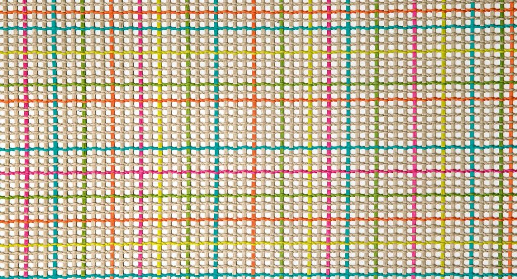 Nilo rug in white, red, green and blue kimia fabric on a white background.