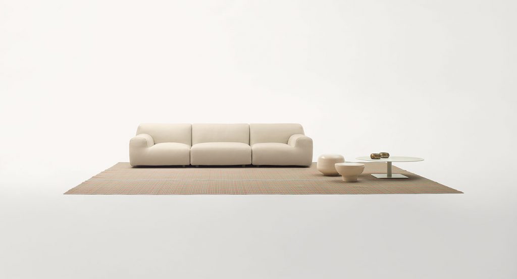 Nilo rug in white, red, green and blue kimia fabric in a living room.