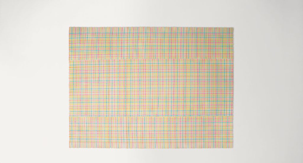 Nilo rug in white, red, green and blue kimia fabric on a white background.
