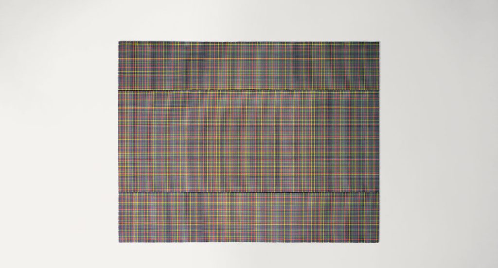 Nilo rug in black, orange, red, tellow and green kimia fabric on a white background.