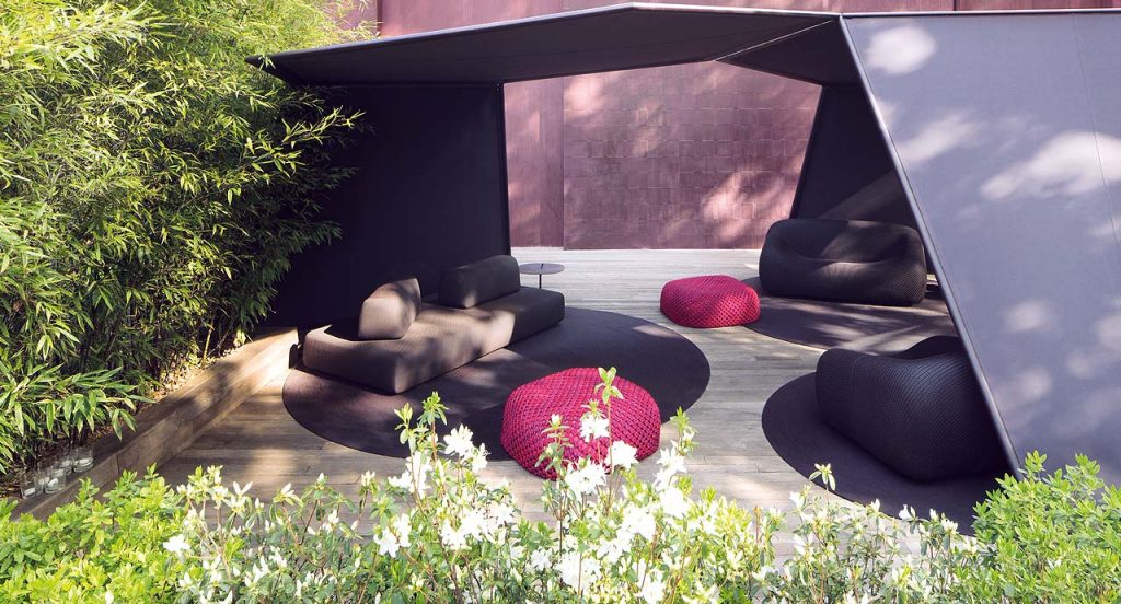 Orlando Outdoor Sectional with backrest, upholstered in grey fabric in a terrace.