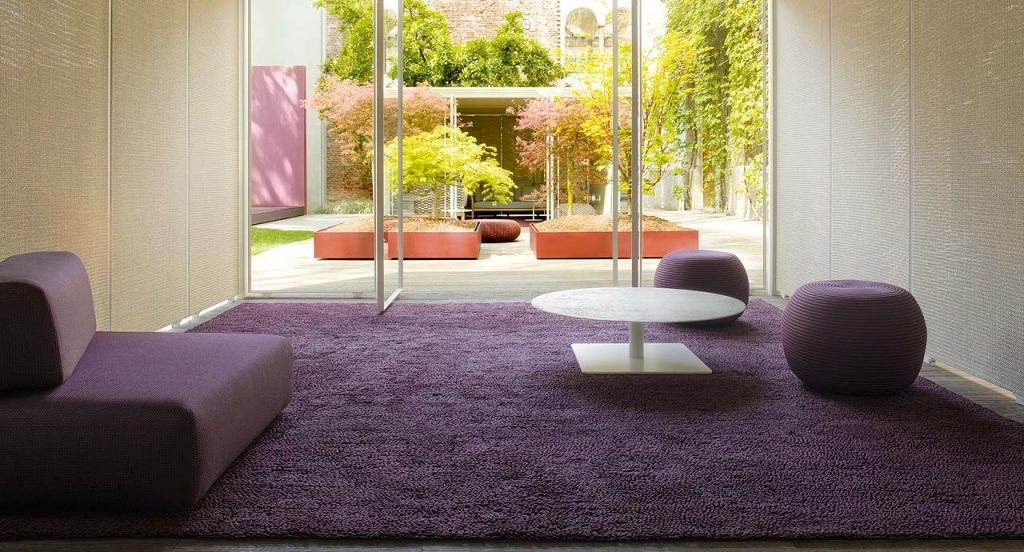 Orlando Outdoor Sectional with backrest, upholstered in grey fabric in a living room.