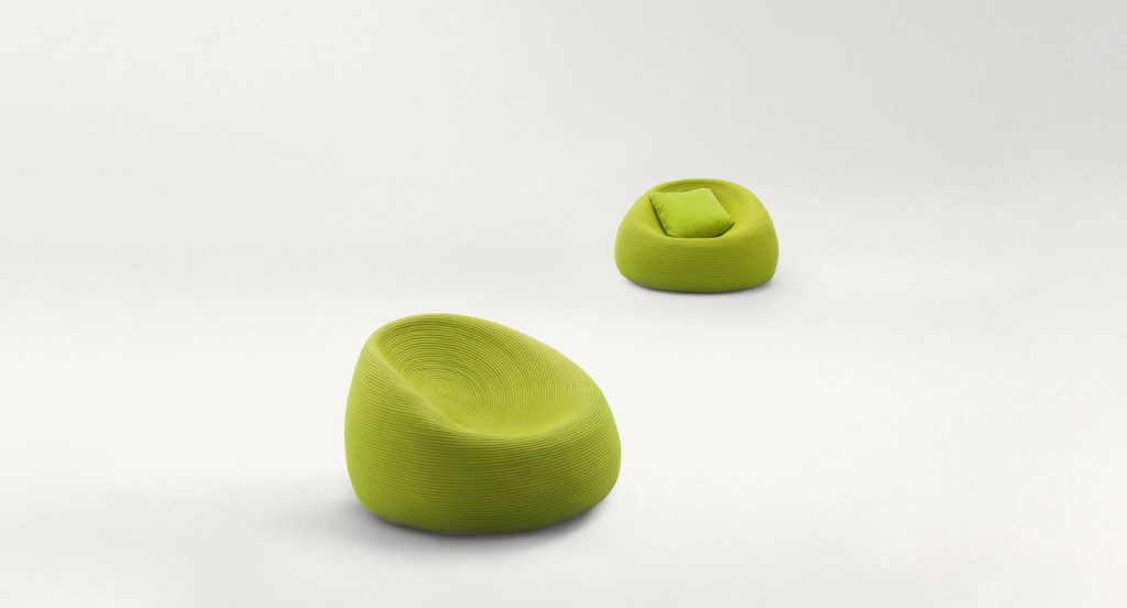 Two Otto Armchairs, upholstery in green rope cord on a white background.