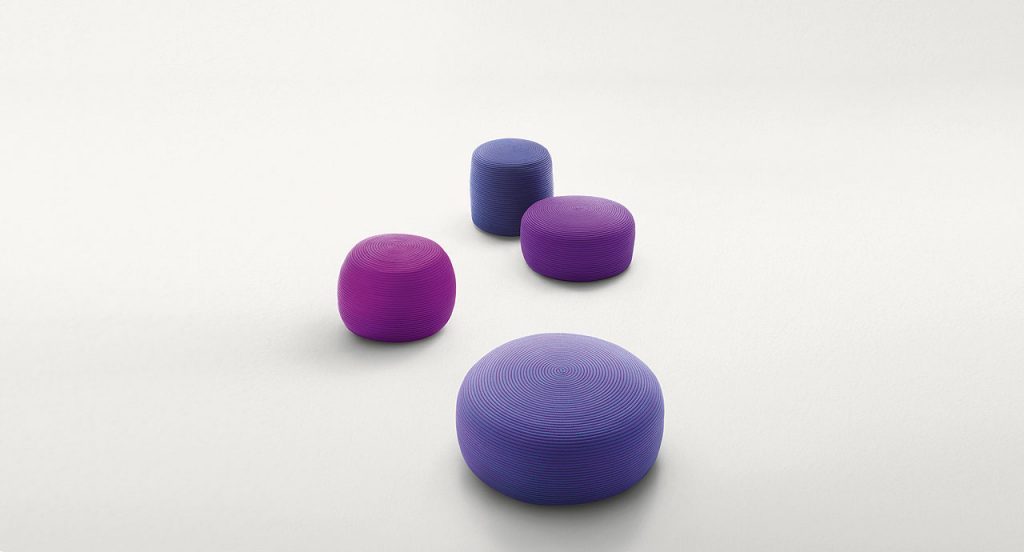 Four round Otto Pouf, upholstery in purple rope cord on a white background.