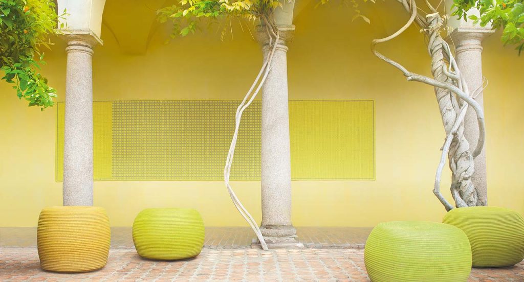 Four round Otto Pouf, upholstery in rope cord , three in green and one in yellow in a indoor garden.