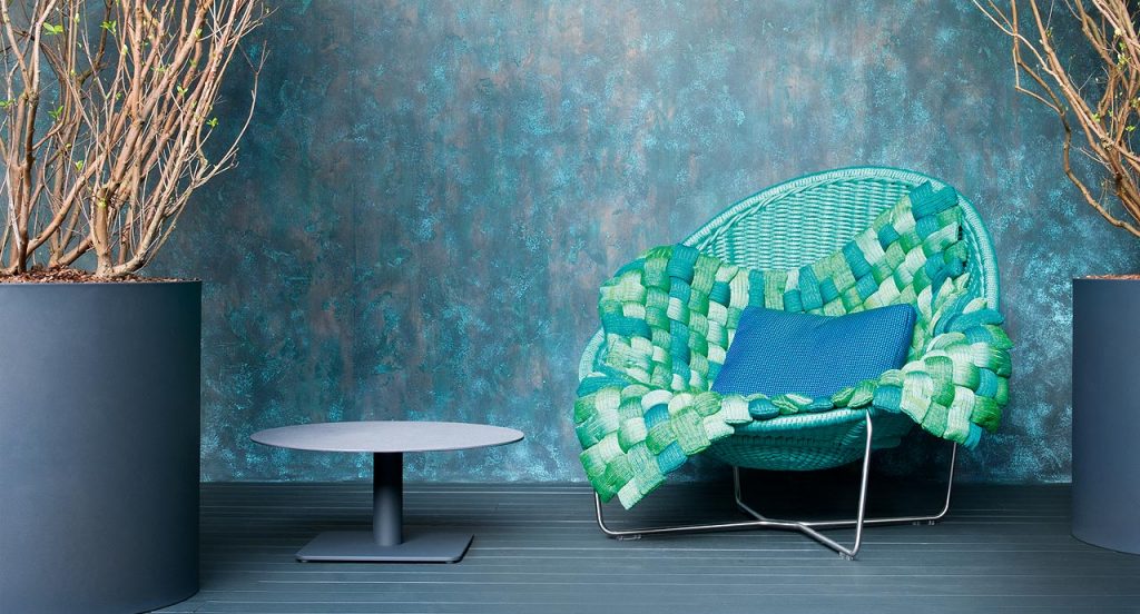 Plump pad Chain Outodoor tubular knit, padding in blue, green and white polyester fiber on a sofa in a living room.